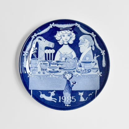 Gustavsberg Christmas Plates (1981-1985) blue and white decorative plate by Stig Lindberg showing a festive family table scene and 1985 date