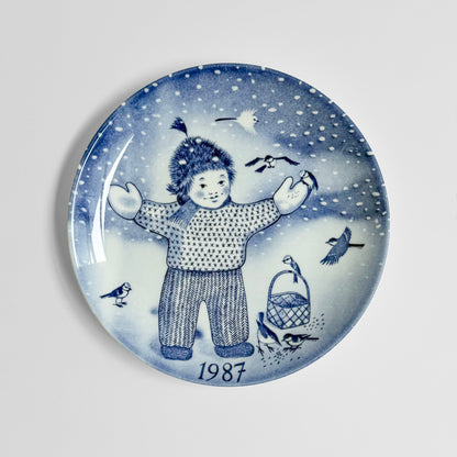 Gustavsberg Christmas Plates (1986-1994) blue and white decorative plate featuring a child in winter clothing snowflakes birds and 1987 design