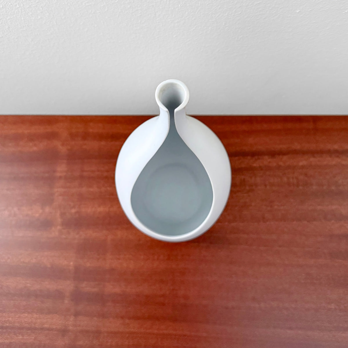 Gustavsberg Pungo White Vase (19 cm) made of ceramic with a smooth white Carrara glaze, showcasing a unique Nordic design by Stig Lindberg, photographed from above on a wooden surface.