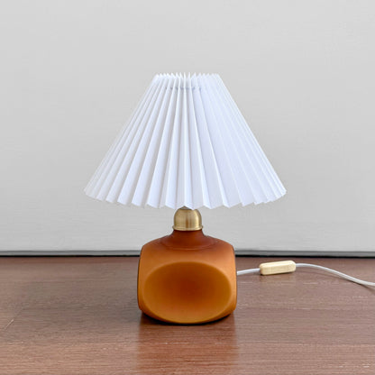 Le Klint 312 Amber Opal Glass Table Lamp with amber glass base and white pleated plastic shade, a vintage lighting piece reflecting Nordic craftsmanship and design.