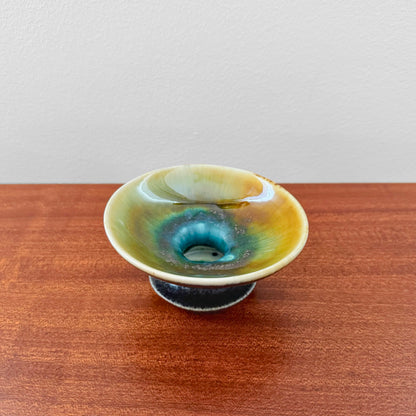 Liisa Hallamaa Arabia Finland Hand-Painted Candle Holder in ceramic, featuring a vintage multicolored glaze with blue and green hues, displayed on a wooden surface.