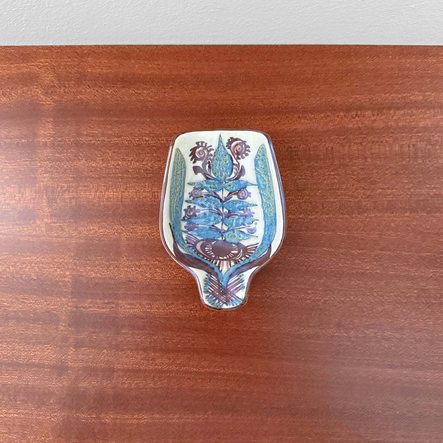 Marianne Johnson Royal Copenhagen Tenera Spoon Rest (414/2900) with stylised floral motif on a vintage ceramic dish for Nordic tableware