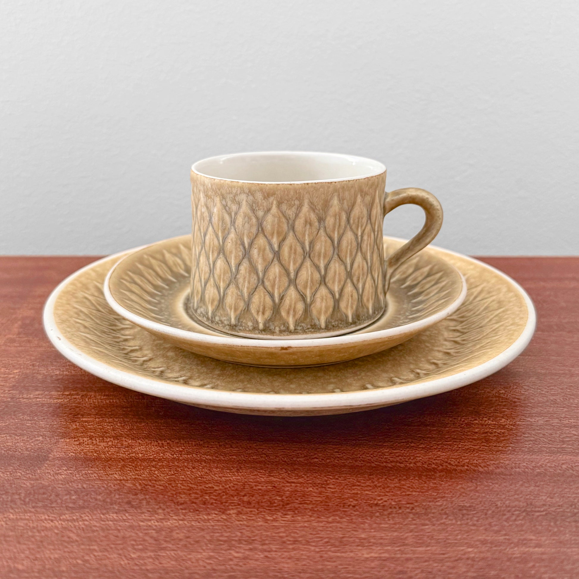 Quistgaard Relief Tea Cup Trio Set with Large Cake Plate featuring textured beige ceramic with a vintage Nordic design, perfect for elegant drinkware and home decor.