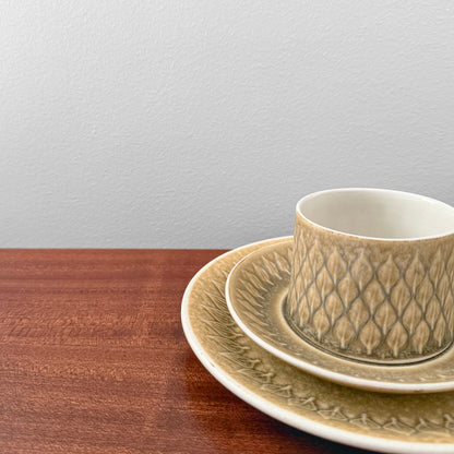 Quistgaard Relief Tea Cup Trio Set with Large Cake Plate featuring textured ceramic drinkware with intricate vintage Nordic design on a wooden surface against a plain background.