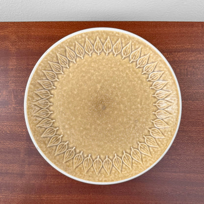 Quistgaard Relief Tea Cup Trio Set with Large Cake Plate featuring a vintage ceramic cake plate with a textured leaf relief design in warm beige tones on a wooden surface.