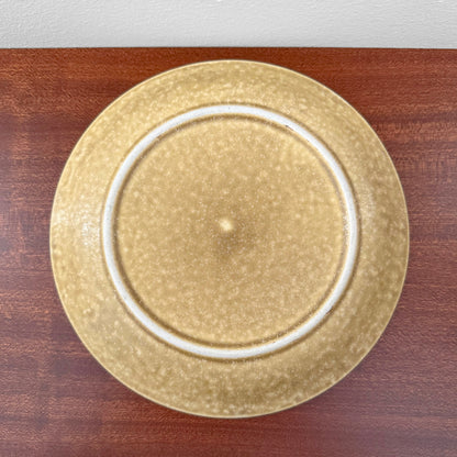 Quistgaard Relief Tea Cup Trio Set with Large Cake Plate showcasing a vintage ceramic cake plate with textured beige glaze on a wooden surface.