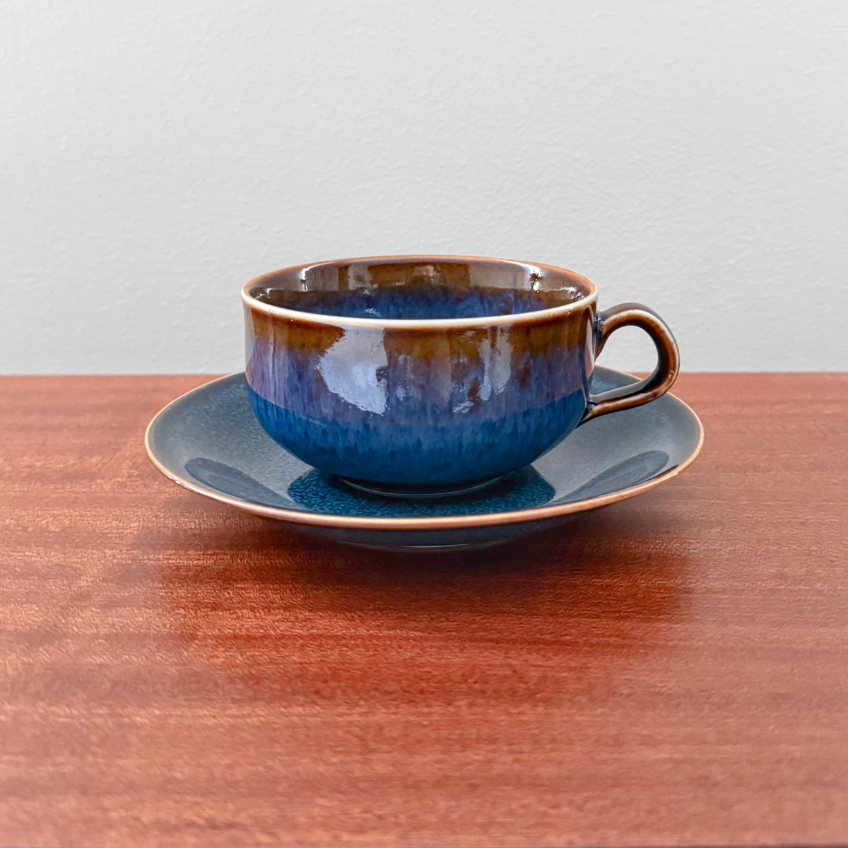 Rörstrand Litorina Blue Tea Cup with Saucer in rich blue glazed ceramic on a wooden table vintage Swedish Nordic tableware by Carl-Harry Stålhane