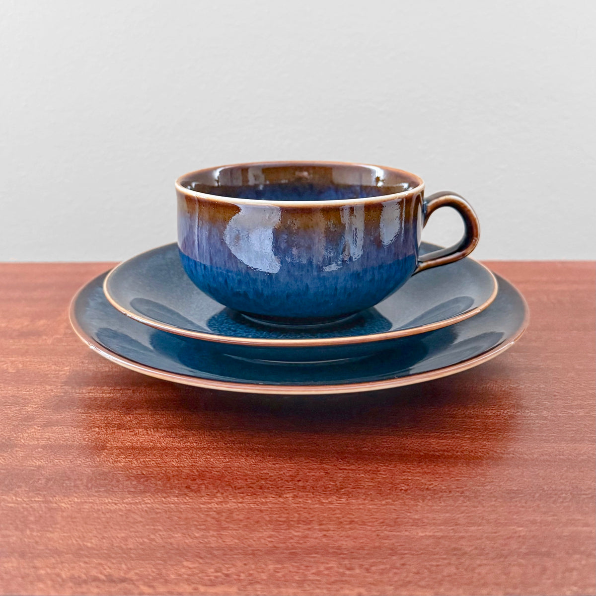Rörstrand Litorina Blue Tea Cup Trio Set with a vintage blue glazed tea cup saucer and cake plate displayed on a wooden table