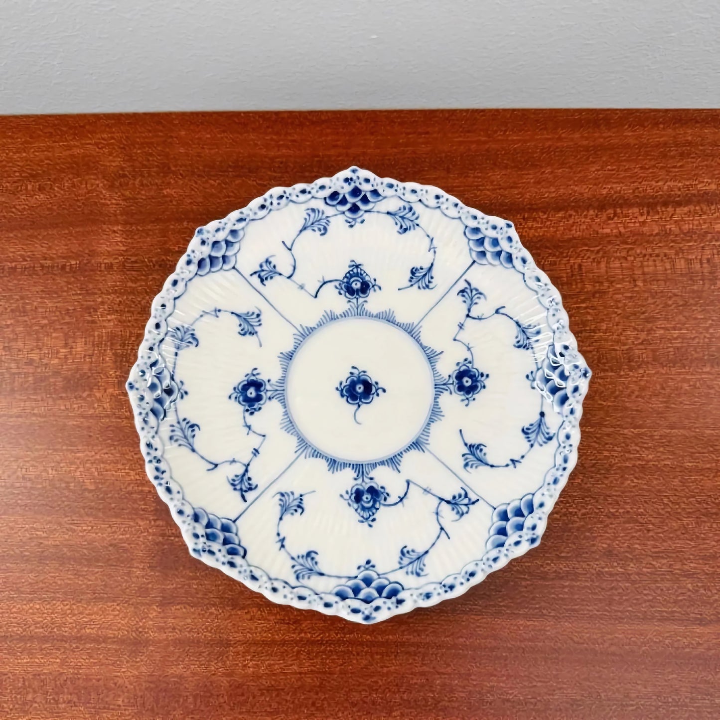 Vintage blue and white ceramic cake plate from the Royal Copenhagen Blue Fluted Full Lace Large Tea Cup Trio Set, featuring intricate Nordic floral patterns and scalloped edges.