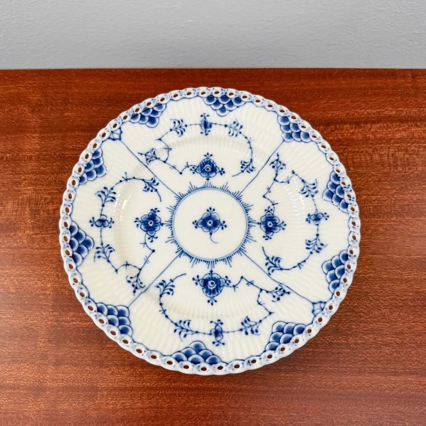 Vintage Royal Copenhagen Blue Fluted Full Lace Large Tea Cup Trio Set cake plate with intricate blue floral and lace patterns on white ceramic, showcasing Nordic craftsmanship.