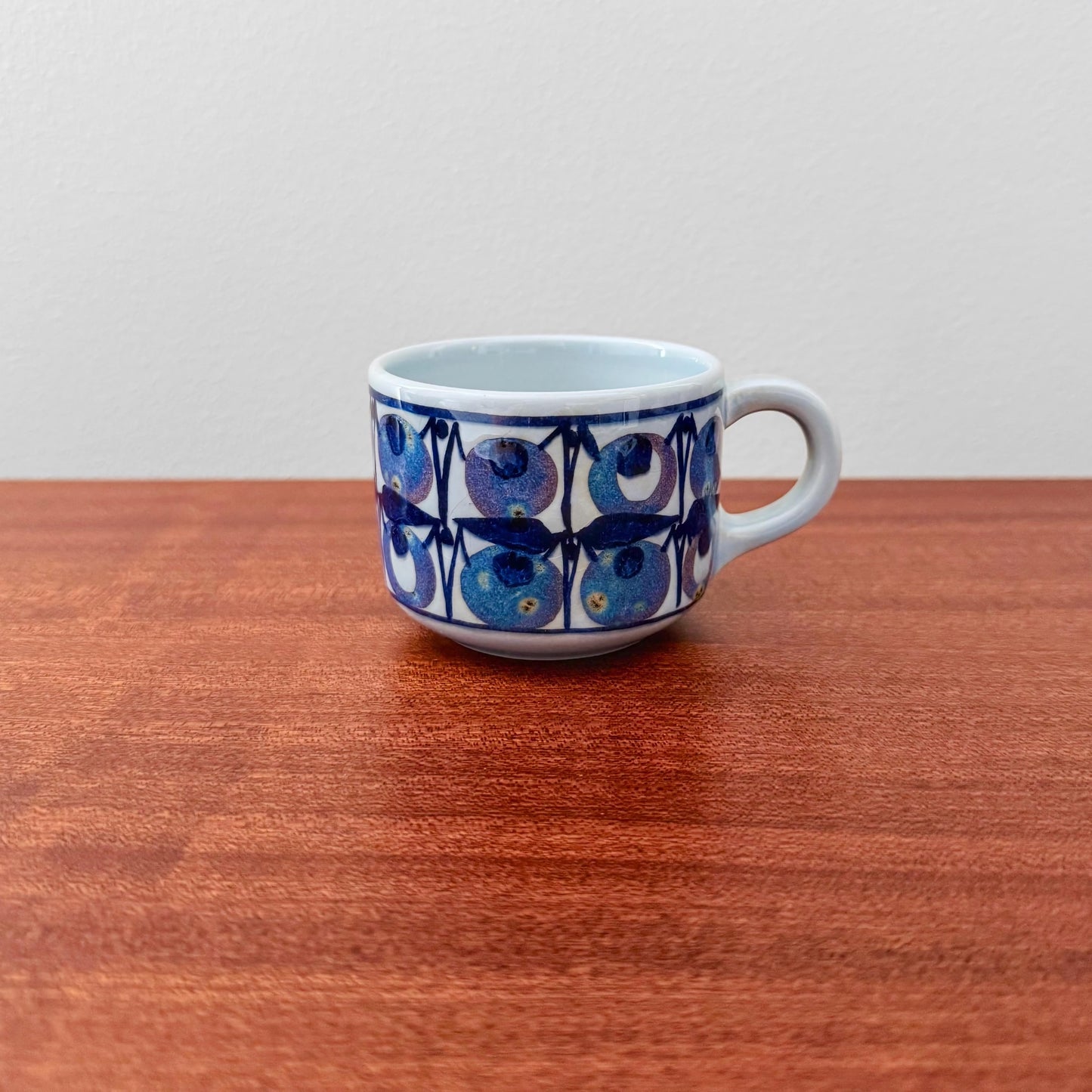 Royal Copenhagen Tenera Coffee Cup (510/3287) vintage ceramic drinkware with a blue stylised blueberry motif and white handle on a wooden table