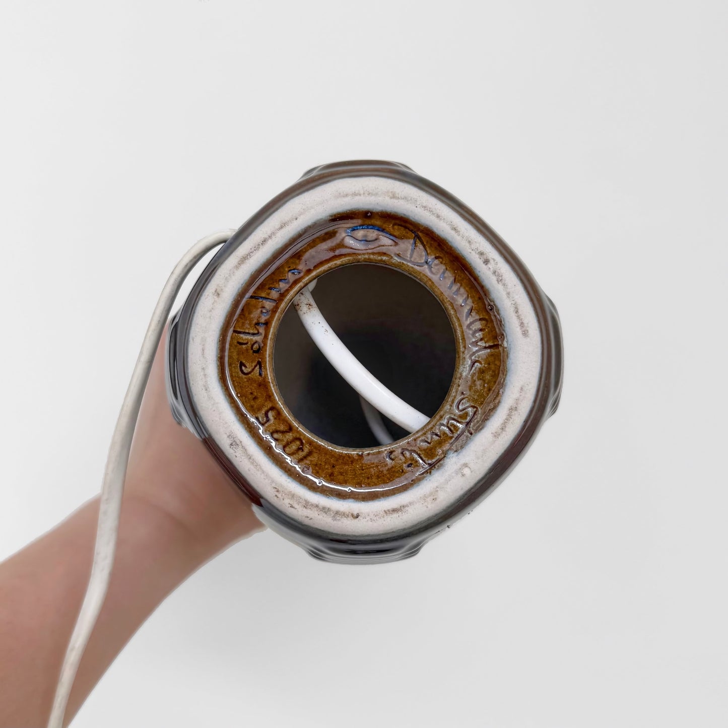 Bottom view of the Søholm 1025 Blue Stoneware Table Lamp showing the ceramic base with brown glaze and the electric cord inside.