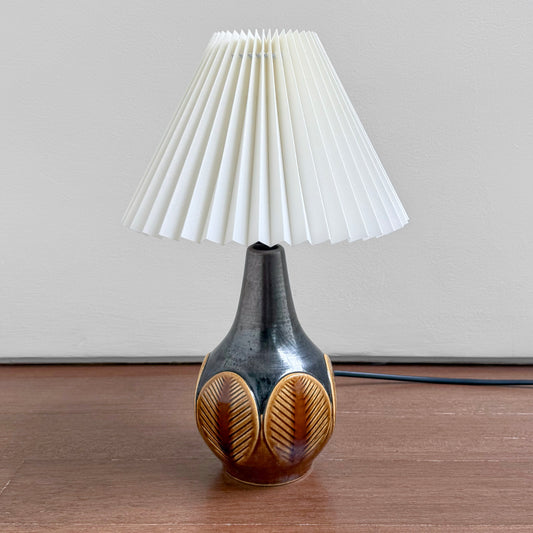 Søholm 1048 Black-Brown Stoneware Table Lamp with leaf relief ceramic base and white pleated shade on a wooden surface