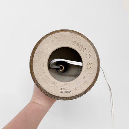 Underside view of Søholm 3043 Black-Blue Stoneware Table Lamp showing ceramic base with maker’s stamp and model number, held by a hand with attached electrical cord.