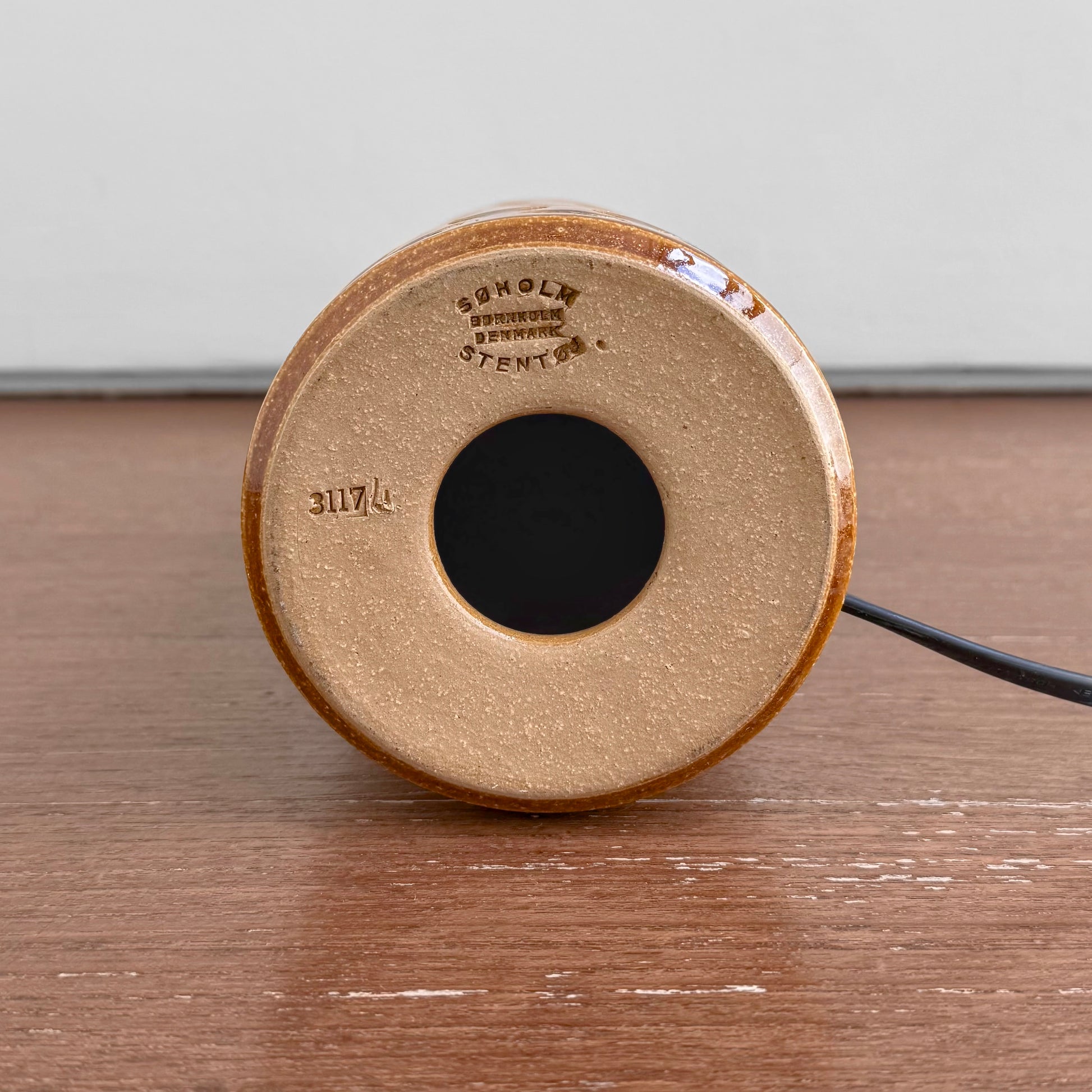 Underside of the Søholm 3117 Brown-Green Stoneware Table Lamp showing maker's stamp and model number on ceramic base against wooden surface.