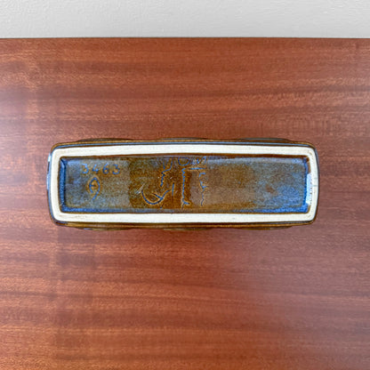 Bottom view of Søholm 3463 Blue Stoneware Candle Holder showing the marked stoneware ceramic base with blue and brown glaze on a wooden surface.