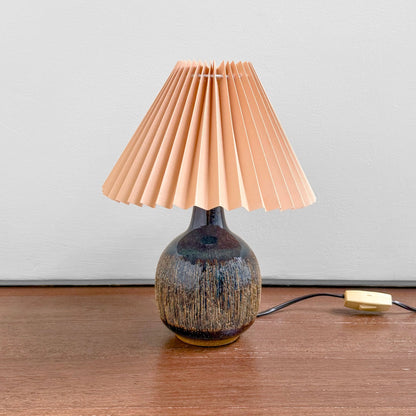 Søholm Black-Brown Stoneware Table Lamp with multitone ceramic base and pleated plastic shade on a wooden surface, showcasing vintage Nordic craftsmanship.