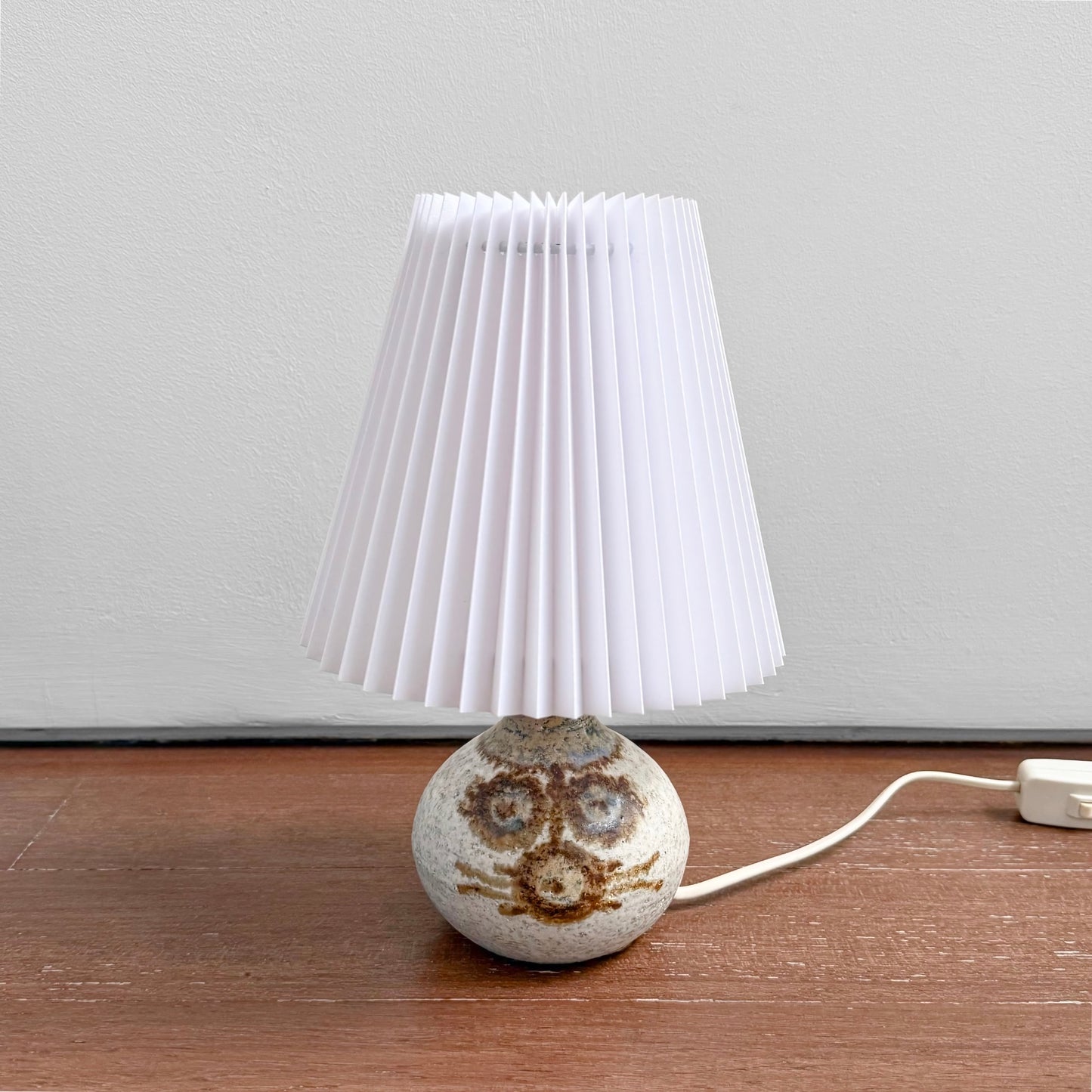 Søholm Erika Small Stoneware Table Lamp with ceramic round base featuring a decorative pattern and topped with a white pleated plastic shade, vintage Nordic design.