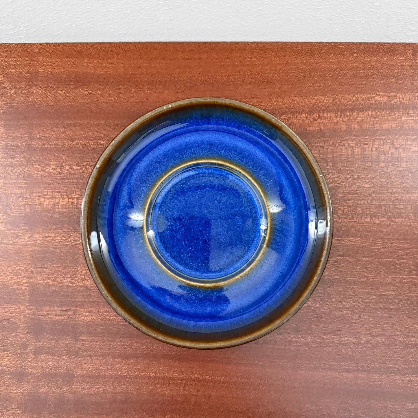 Søholm Granit Blue Tea Cup with Saucer showcasing a deep blue ceramic saucer with brown edges, highlighting vintage Scandinavian craftsmanship and Nordic design.