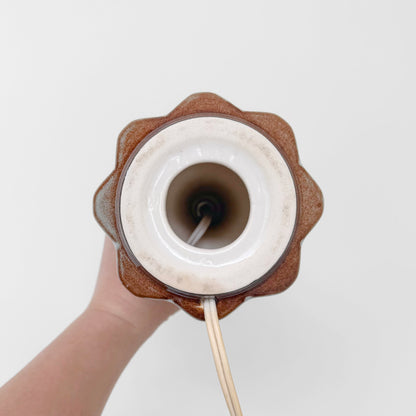 Søholm Grey-Brown Stoneware Table Lamp viewed from above, showing its brown ceramic base, white socket surround, and attached electrical cord.