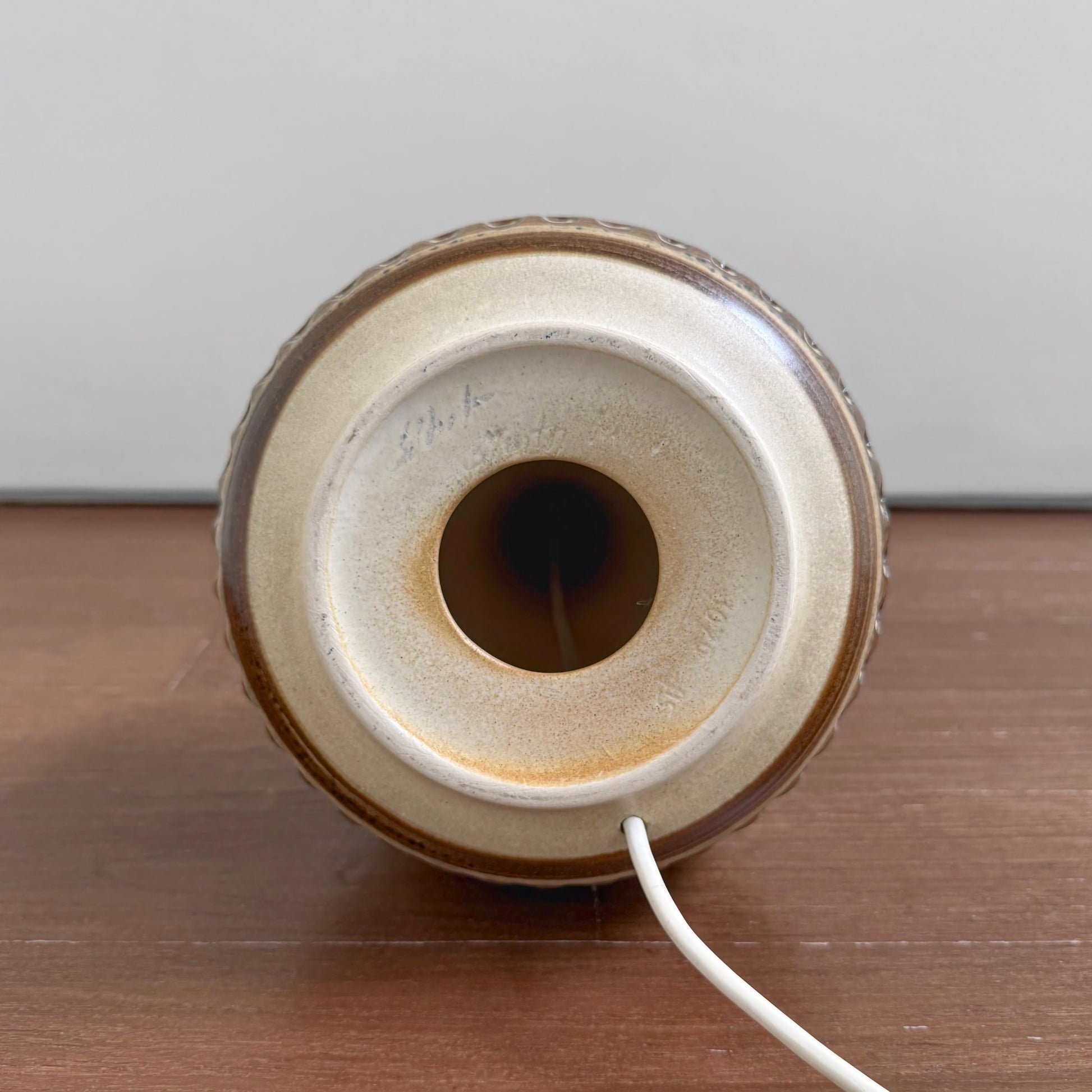 Bottom view of the Søholm 3070 Large Earthy Stoneware Table Lamp showing the ceramic base with earthy glaze and the white electrical cord emerging from the center.