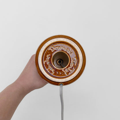 Bottom view of Søholm Manilla Small Brown Stoneware Table Lamp showing circular ceramic base with Denmark marking and attached power cord.