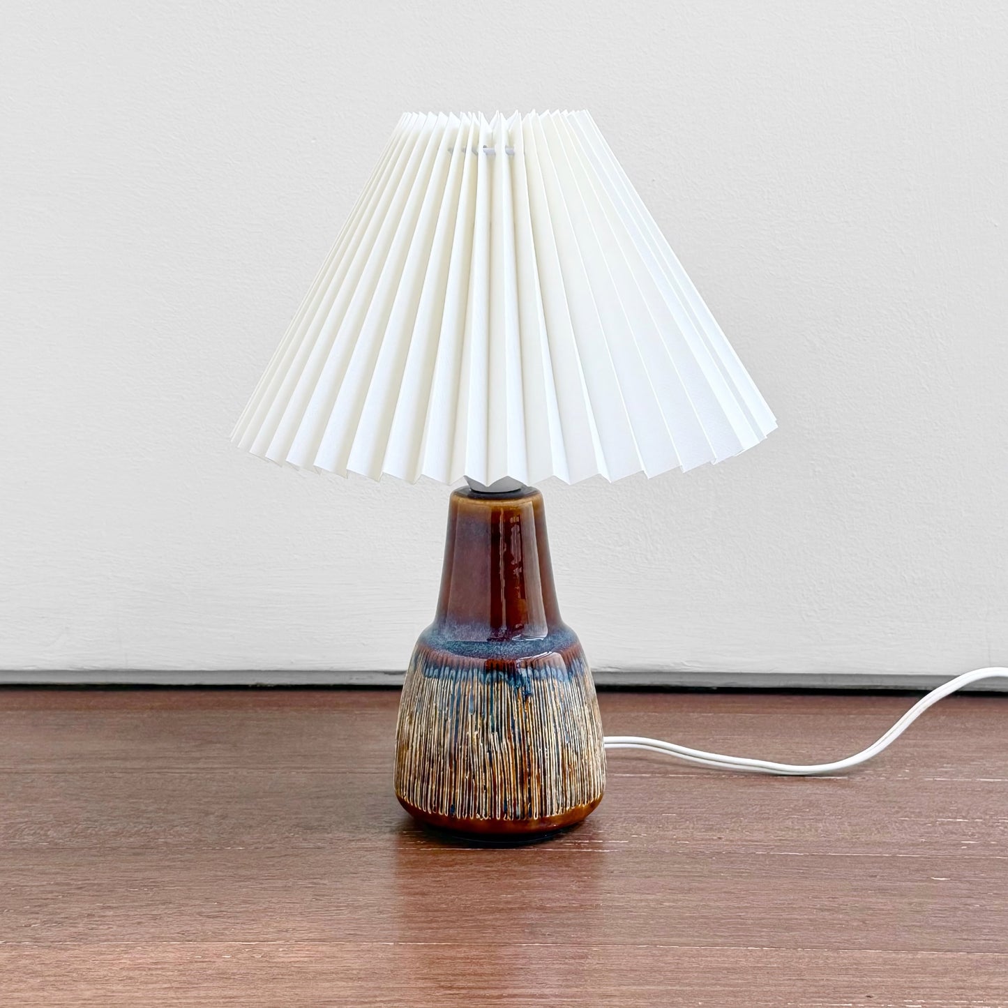 Søholm Manilla Brown Stoneware Table Lamp with multitone ceramic base and white pleated plastic shade, showcasing vintage Scandinavian design and Nordic craftsmanship.