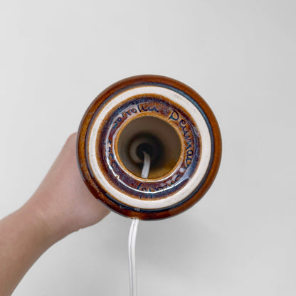 Bottom view of vintage Søholm Manilla Brown Stoneware Table Lamp showing ceramic base with multitone glaze and maker’s mark, held by hand against a plain background.