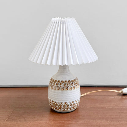 Søholm White Stoneware Table Lamp with a textured white ceramic base and pleated shade displayed on a wooden surface