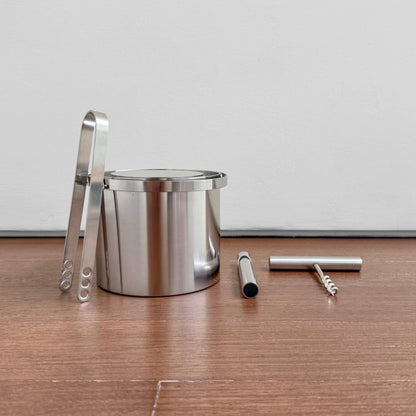 Stelton Stainless Steel Bar Set featuring a polished metal ice bucket with tongs, a bottle opener, and a corkscrew, showcasing vintage Scandinavian design.