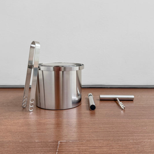 Stelton Stainless Steel Bar Set featuring a polished metal ice bucket with tongs, a bottle opener, and a corkscrew, showcasing vintage Scandinavian design.