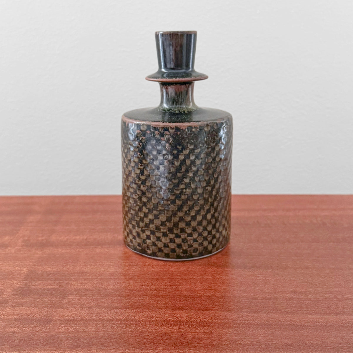 Stig Lindberg Gustavsberg Brown Stoneware Vase vintage brown ceramic vase with textured checkerboard glaze and narrow neck displayed on a wooden table