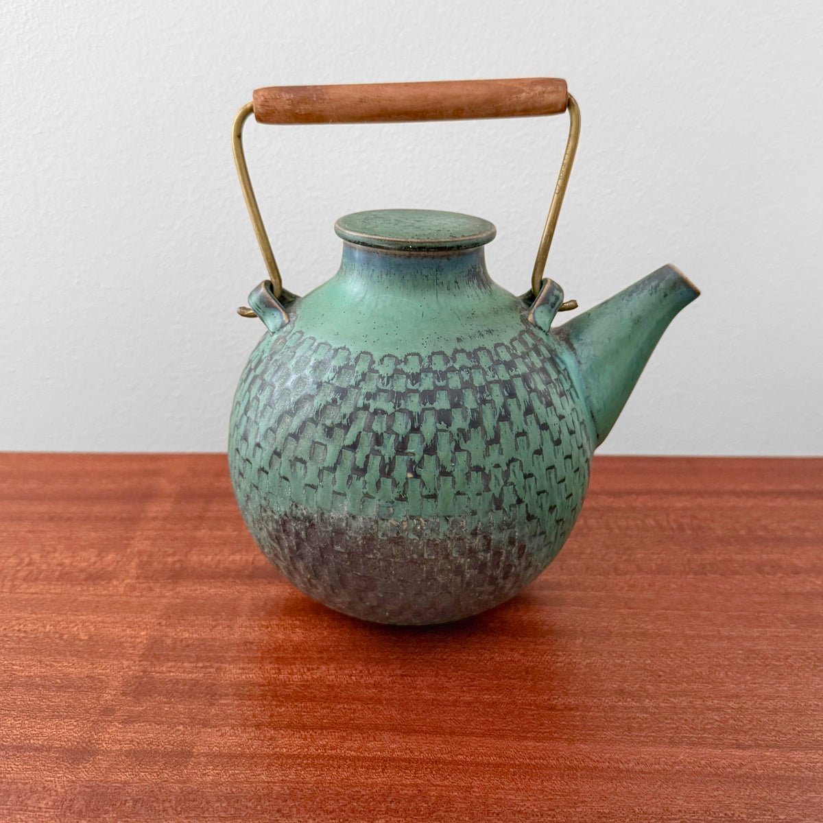 Stig Lindberg Gustavsberg Turquoise Stoneware Teapot with textured turquoise glaze and brass and teak handle on a wooden table