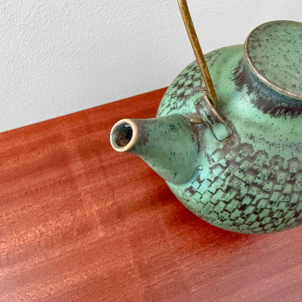 Stig Lindberg Gustavsberg Turquoise Stoneware Teapot with textured turquoise glaze and brass handle shown on a warm wood surface
