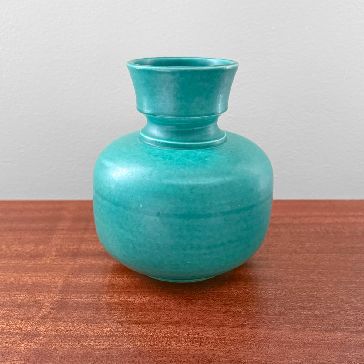 Wilhelm Kåge Gustavsberg Argenta Green Vase vintage green ceramic vase with rounded body and flared neck displayed on a wooden surface